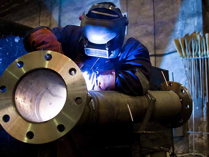 Worker welding a large pipe